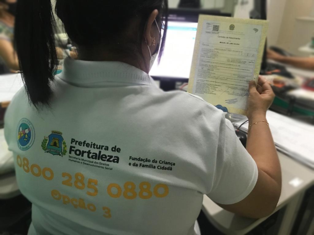 Pessoa no local de trabalho com a certidão de nascimento